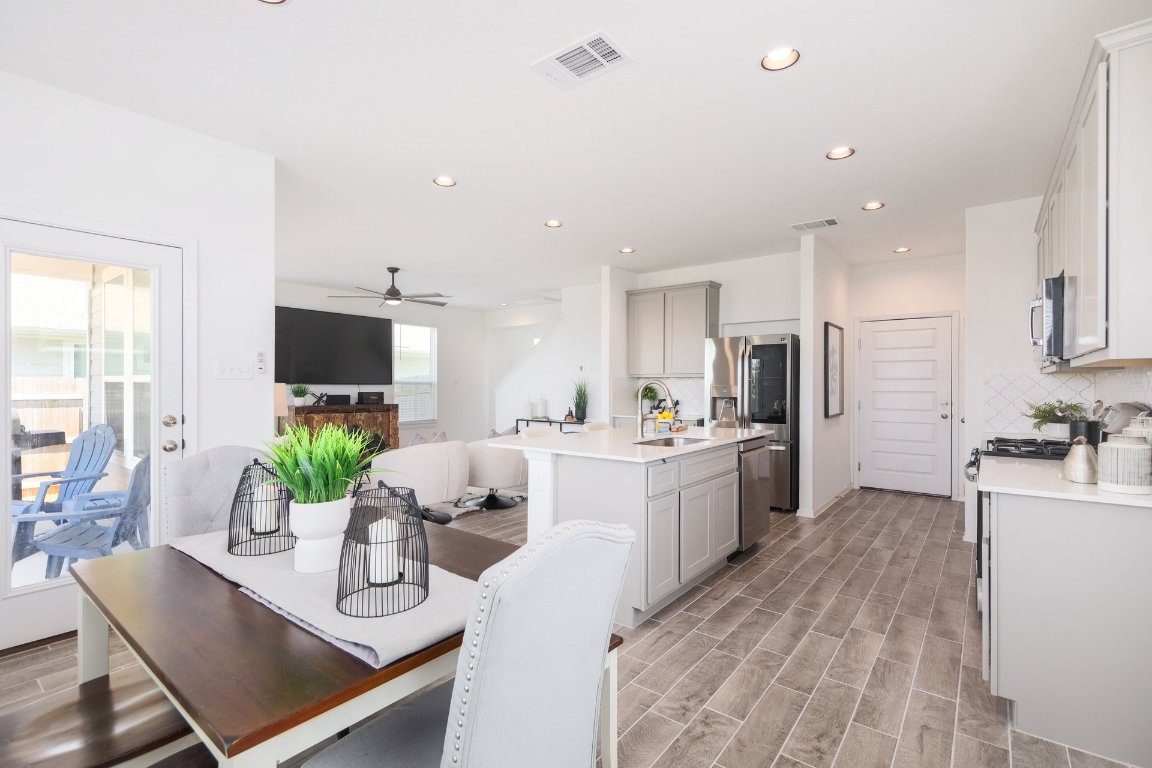 1408 Flint Knapper Drive Georgetown, TX 78626 - Photo 15 of 32 a kitchen with stainless steel appliances kitchen island granite countertop a stove refrigerator and a living room view