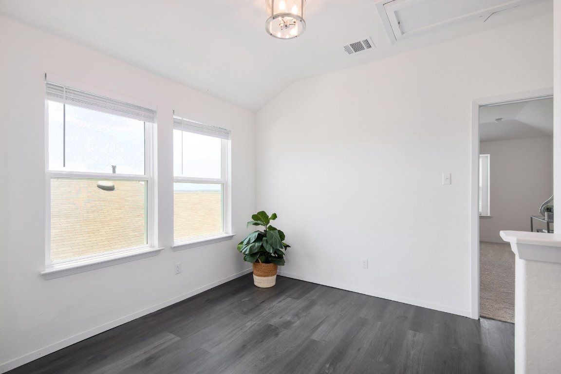 1408 Flint Knapper Drive Georgetown, TX 78626 - Photo 17 of 32 a view of an empty room with wooden floor and a window