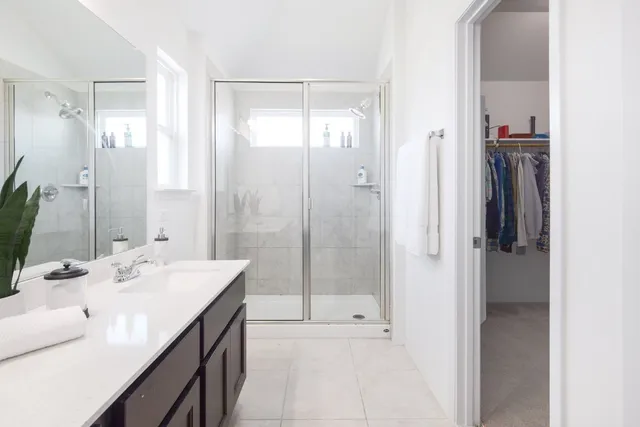 a bathroom with a double vanity sink mirror and shower