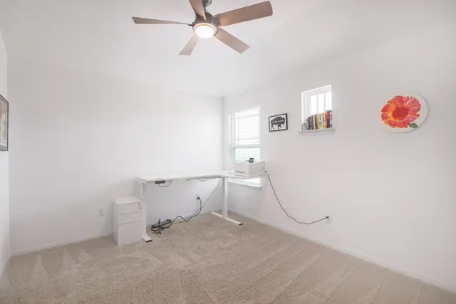an empty room with a window and a fan