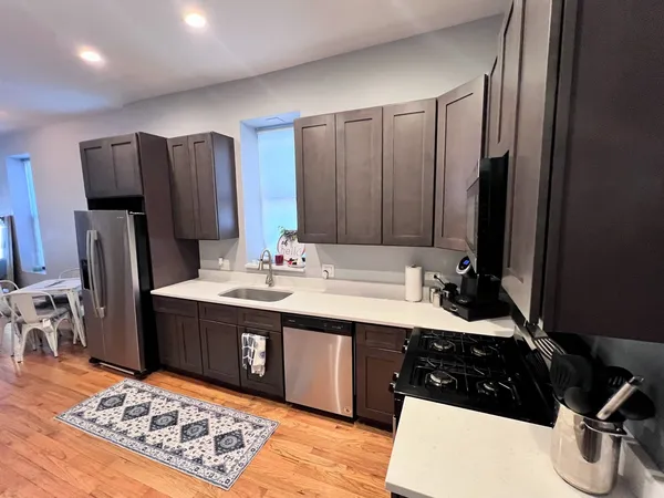 a kitchen with stainless steel appliances granite countertop a sink stove and refrigerator