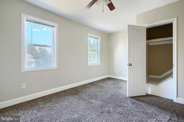 an empty room with windows and closet