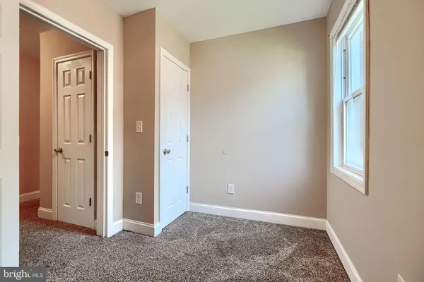 an empty room with windows and closet