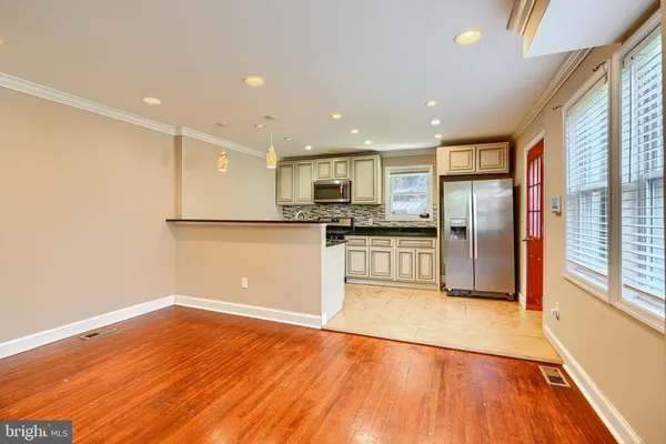 a view of kitchen with refrigerator microwave and wooden floor