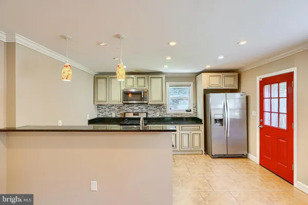 a kitchen with stainless steel appliances granite countertop a refrigerator and a stove top oven
