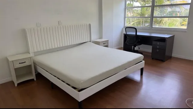 a bed sitting in a bedroom next to a window