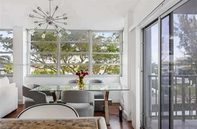 a dining room with furniture large windows and wooden floor