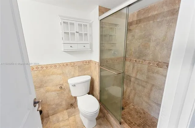 a bathroom with a toilet and a shower