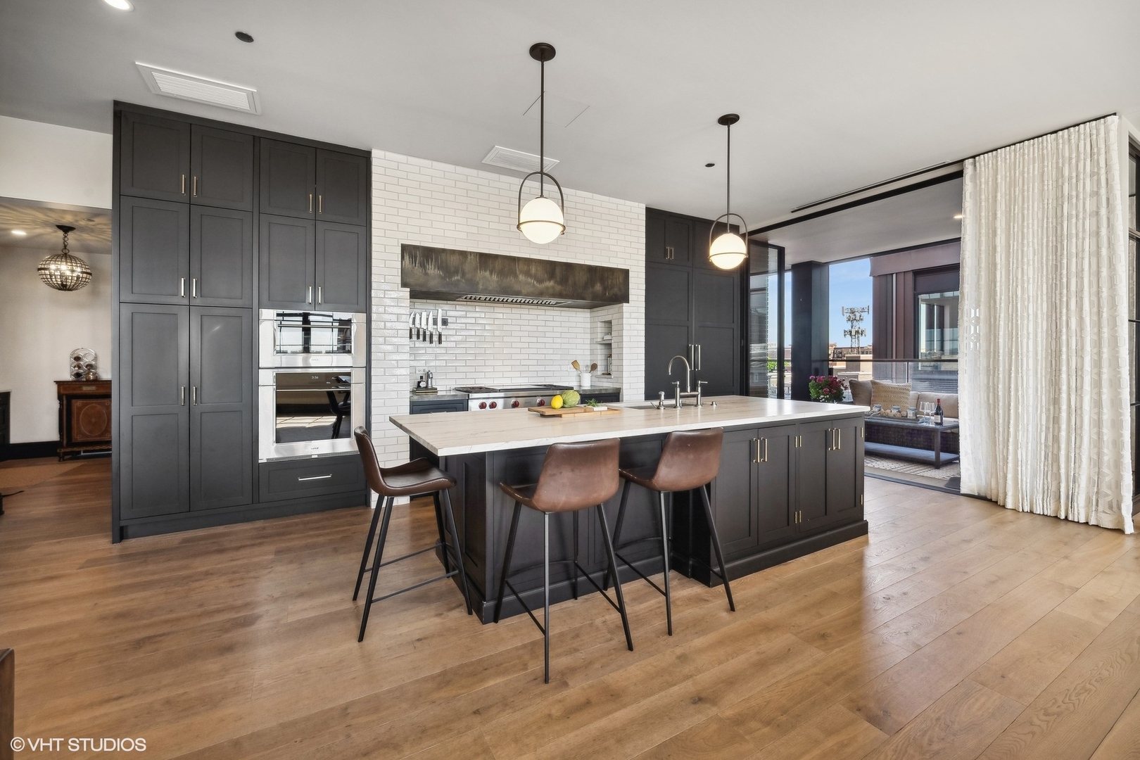 1109 West Washington Boulevard, Unit 6D Chicago, IL 60607 - Photo 22 of 41 a large kitchen with granite countertop wooden floor refrigerator and dining table