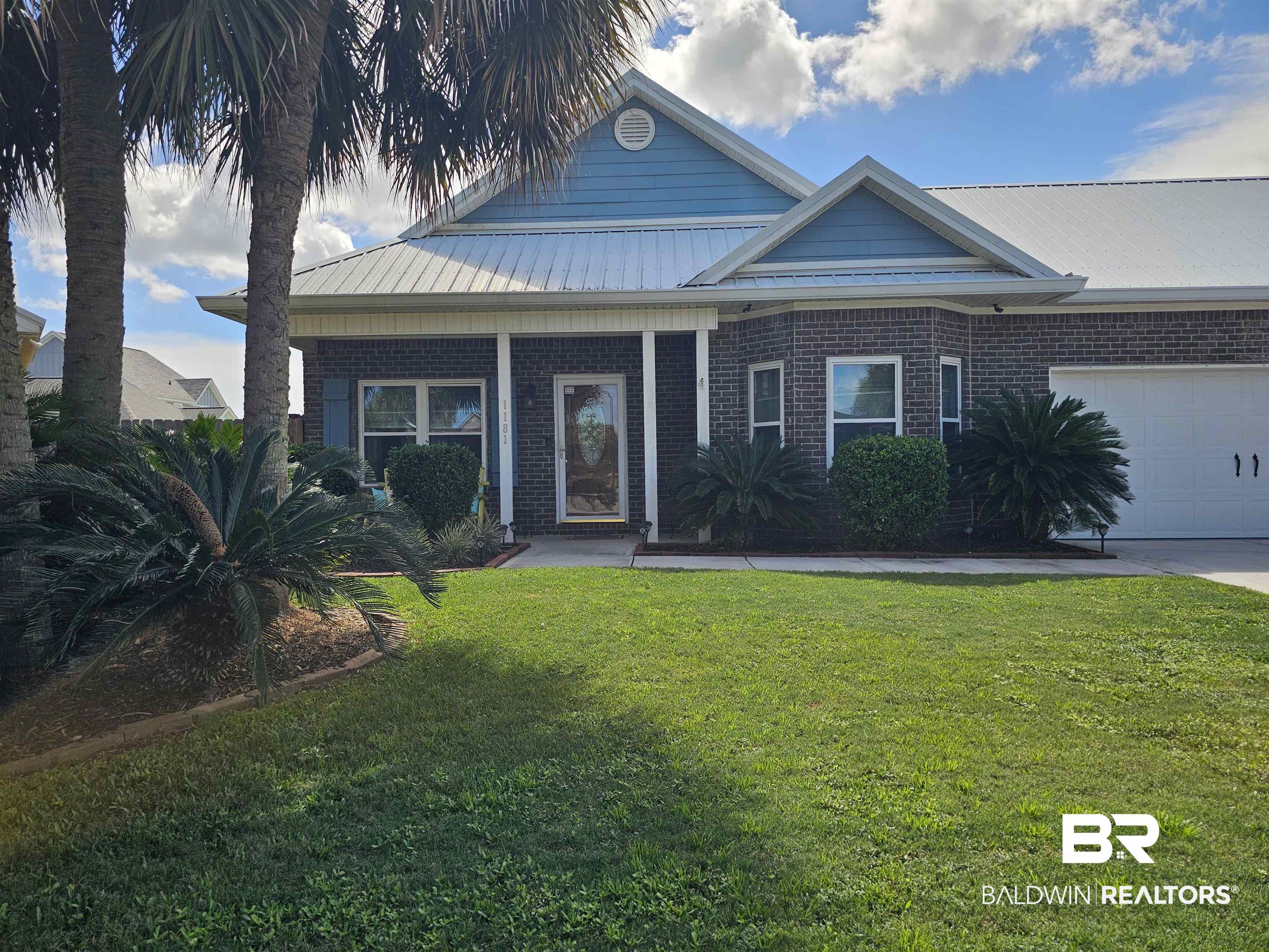 1181 Sloane Cove Foley, AL 36535 - Photo 1 of 10 Brick and siding exterior featuring a covered entry, metal roof, and an attached two-car garage