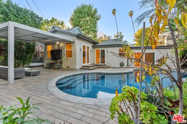 a view of a house with pool and sitting area