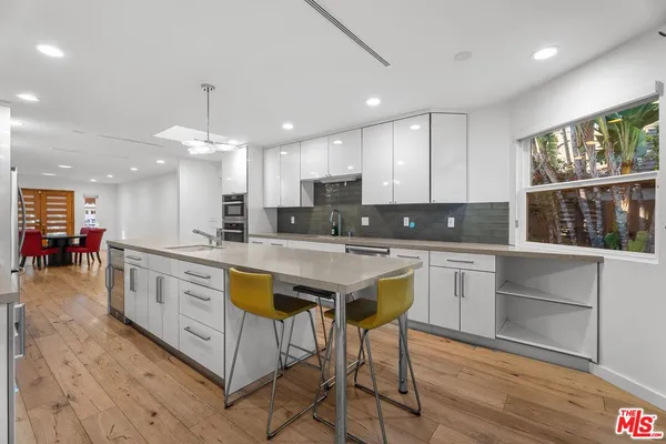 a large kitchen with stainless steel appliances granite countertop a stove a sink and a microwave