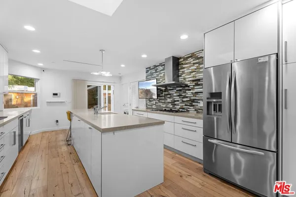 a kitchen with stainless steel appliances a refrigerator sink and microwave
