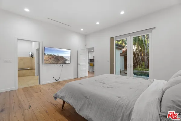 a bedroom with a large bed and a flat screen tv