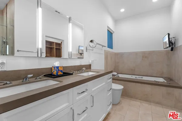a bathroom with a granite countertop sink a toilet and mirror