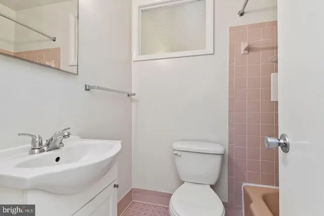 a bathroom with a toilet a sink and mirror