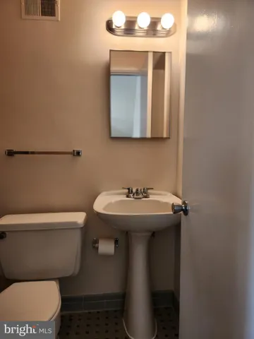 a bathroom with a sink toilet and mirror