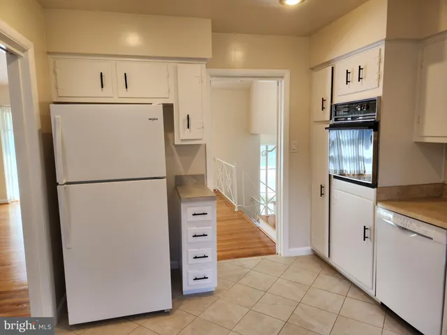 a view of kitchen with refrigerator cabinets and wooden floor