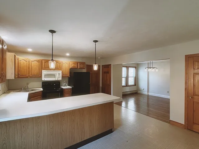 a kitchen with kitchen island a counter top space appliances and a ceiling fan