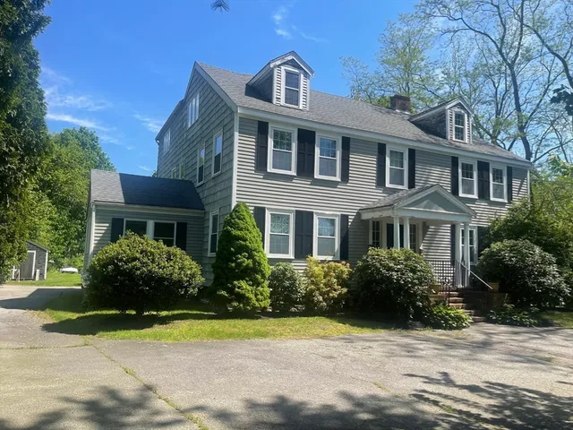 a front view of a house with a yard and trees