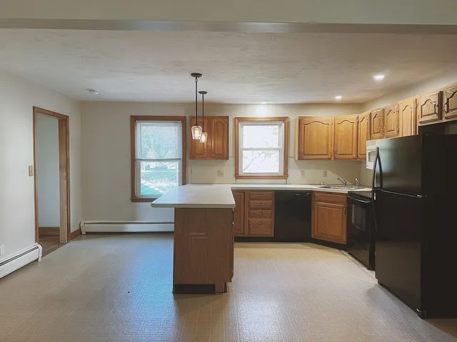 a kitchen with granite countertop a refrigerator and a stove top oven