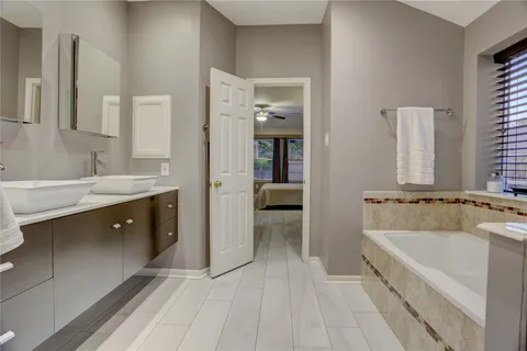 a spacious bathroom with a double vanity sink a mirror and a bathtub