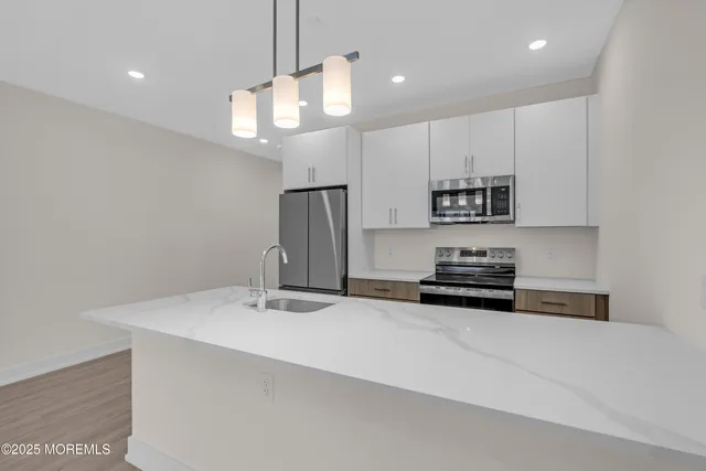 a kitchen with stainless steel appliances a stove a sink and a refrigerator