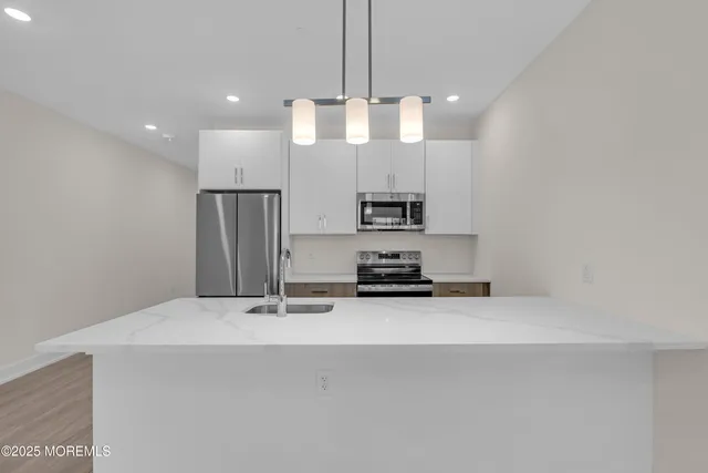 a kitchen with stainless steel appliances a refrigerator sink and microwave