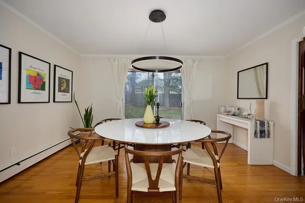 a dining room with furniture and a floor to ceiling window
