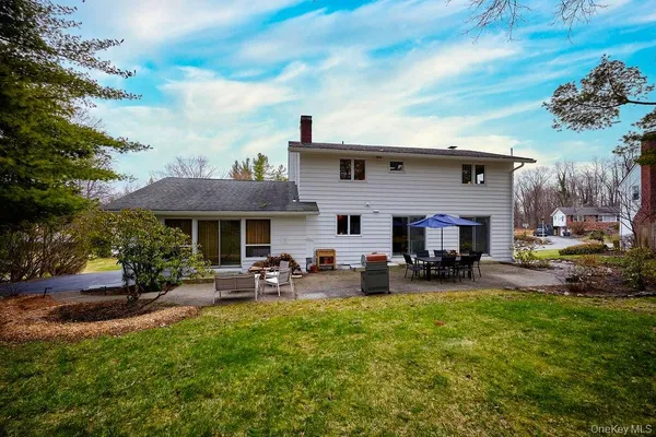 a view of a tables and chairs in the back yard of the house