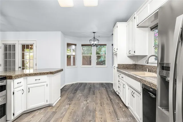 a kitchen with granite countertop a refrigerator sink and cabinets
