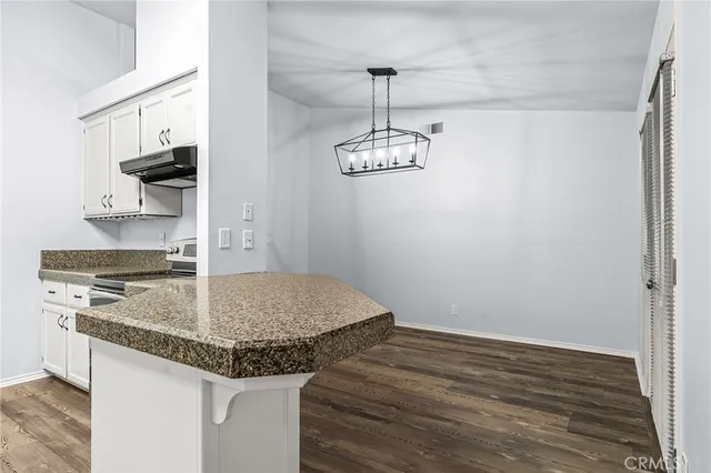 a kitchen with granite countertop a stove a sink and a granite counter tops