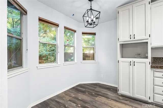 a view of a hallway with wooden floor and a bathroom
