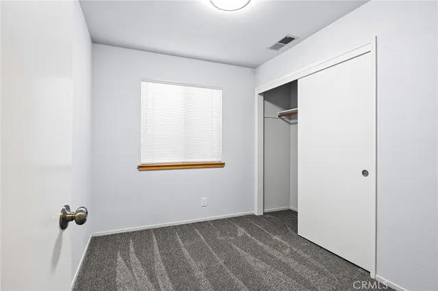 a view of a backyard with large trees and wooden fence