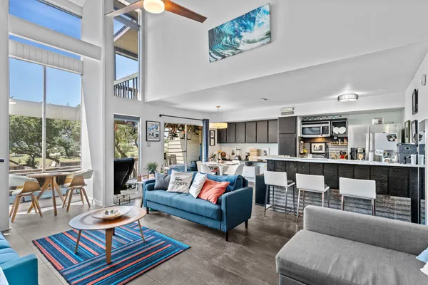 a living room with furniture a rug and a large window