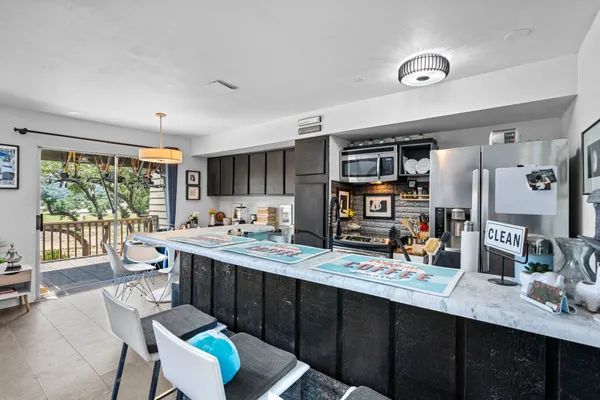 a kitchen with stainless steel appliances a sink stove and large window