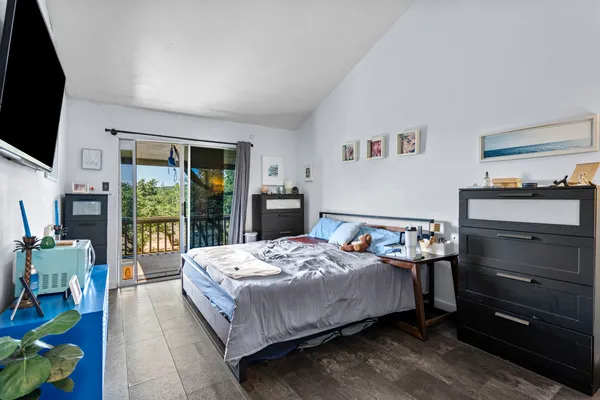 a bedroom with a bed and a flat tv screen