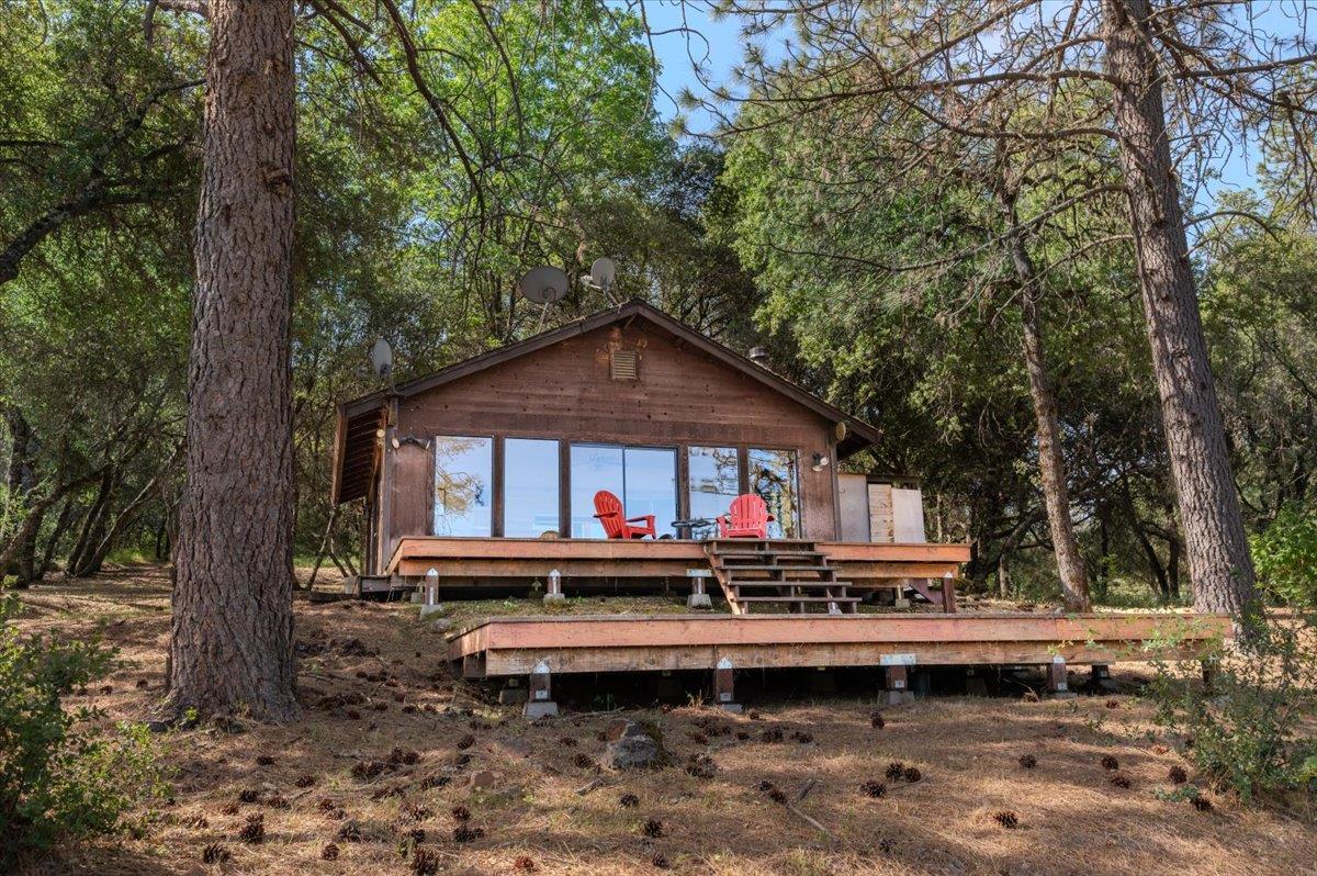 11076 Houghton Ranch Road Penn Valley, CA 95946 - Photo 3 of 41 a wooden bench sitting in front of a forest