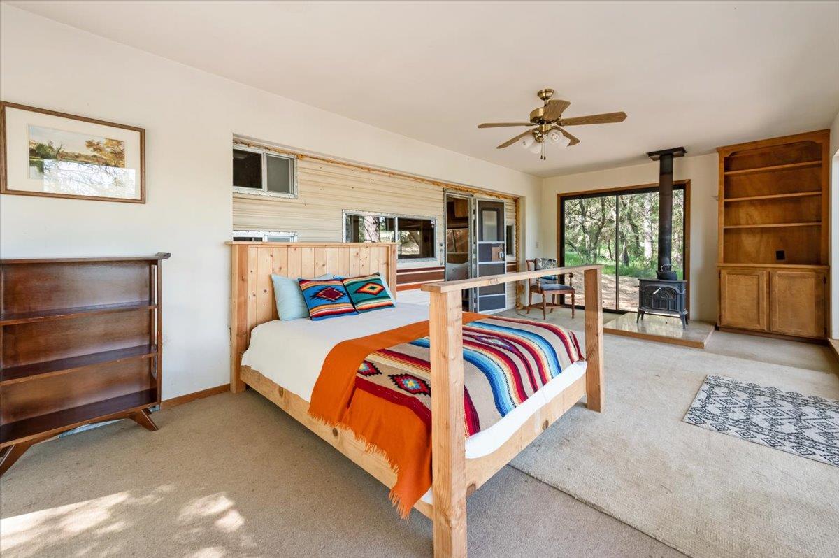 11076 Houghton Ranch Road Penn Valley, CA 95946 - Photo 8 of 41 a bedroom with a large bed and a chandelier