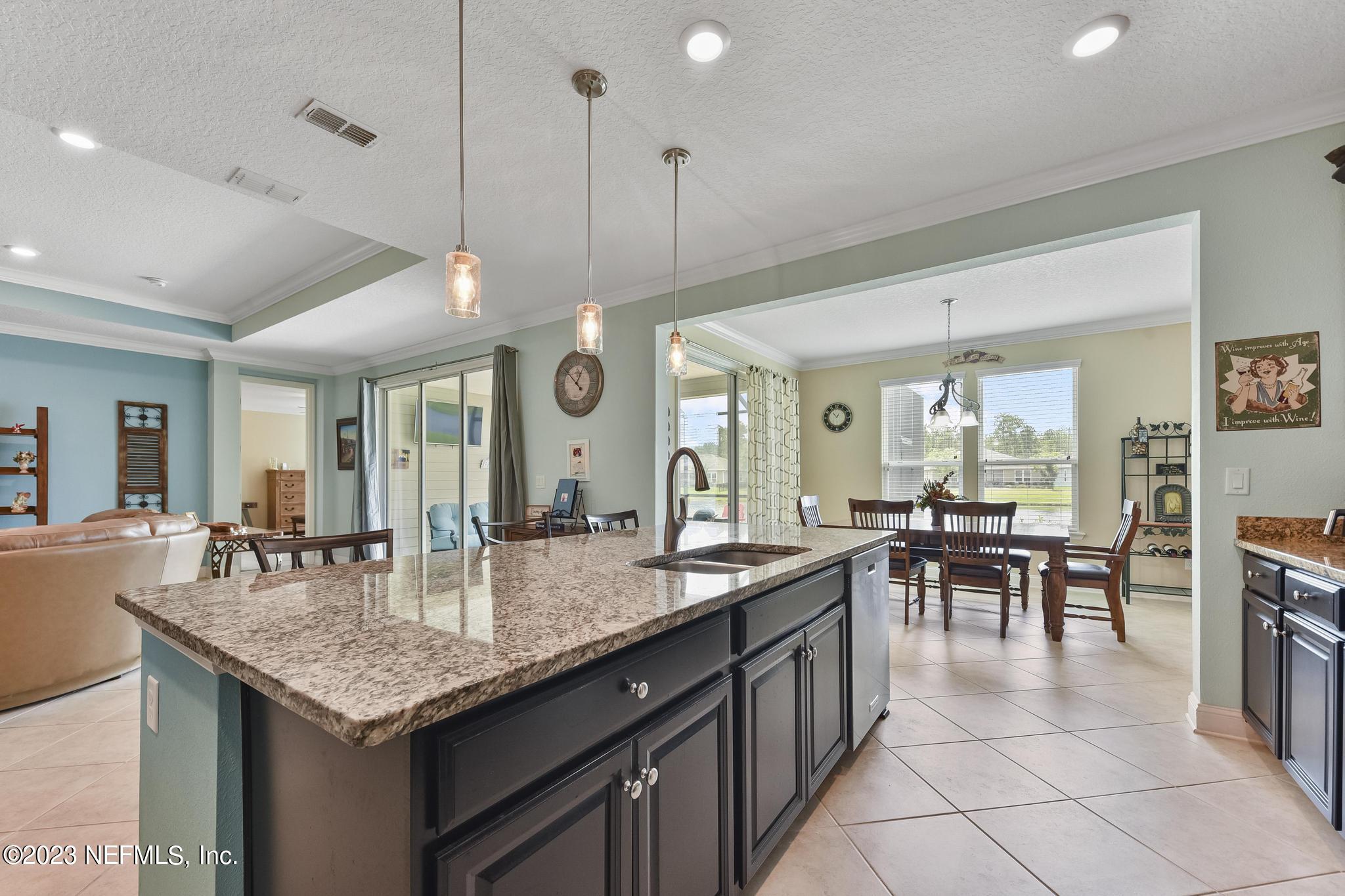 168 St Kitts Loop St. Augustine, FL 32092 - Photo 13 of 41 a kitchen with granite countertop kitchen island a sink dining table and chairs