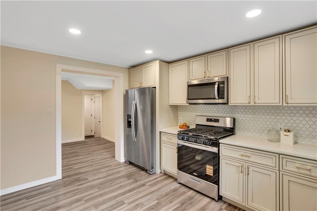 1430 Ridge Avenue Coraopolis, PA 15108 - Photo 16 of 32 a kitchen with granite countertop a refrigerator and a stove top oven