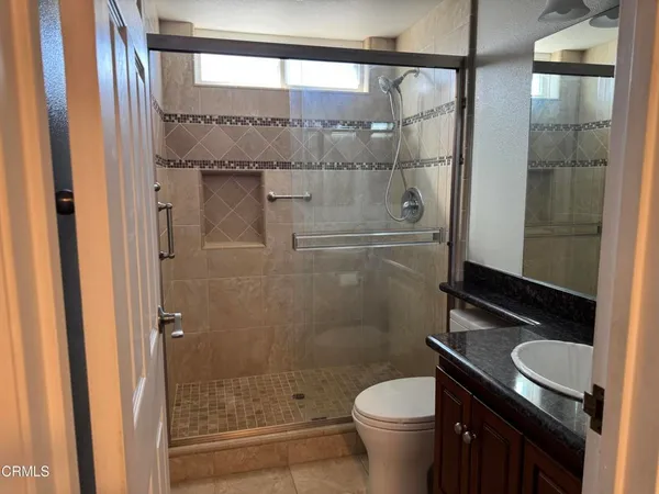 a bathroom with a granite countertop sink toilet and shower