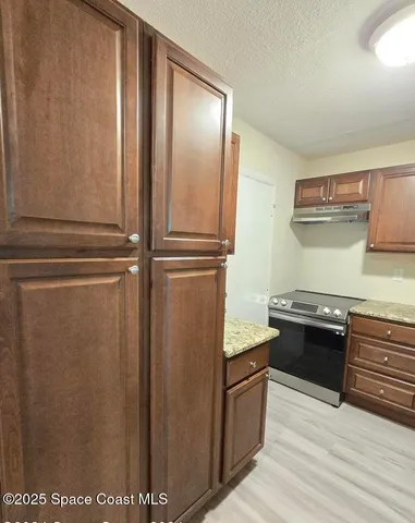 a kitchen with stainless steel appliances granite countertop a refrigerator and a stove