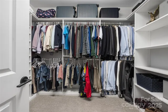 a view of walk in closet with clothes and shoes