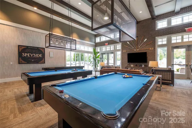 a room with furniture pool table and flat screen tv