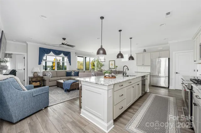 a large white kitchen with a large window and stainless steel appliances