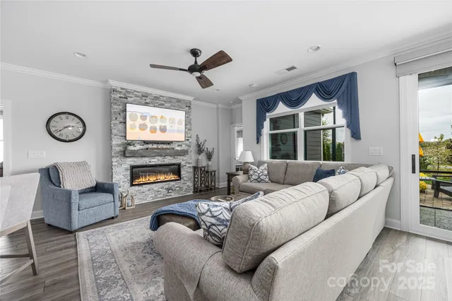 a living room with furniture a fireplace and a large window