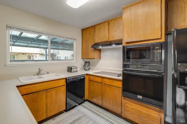 a view of kitchen and hall with wooden floor