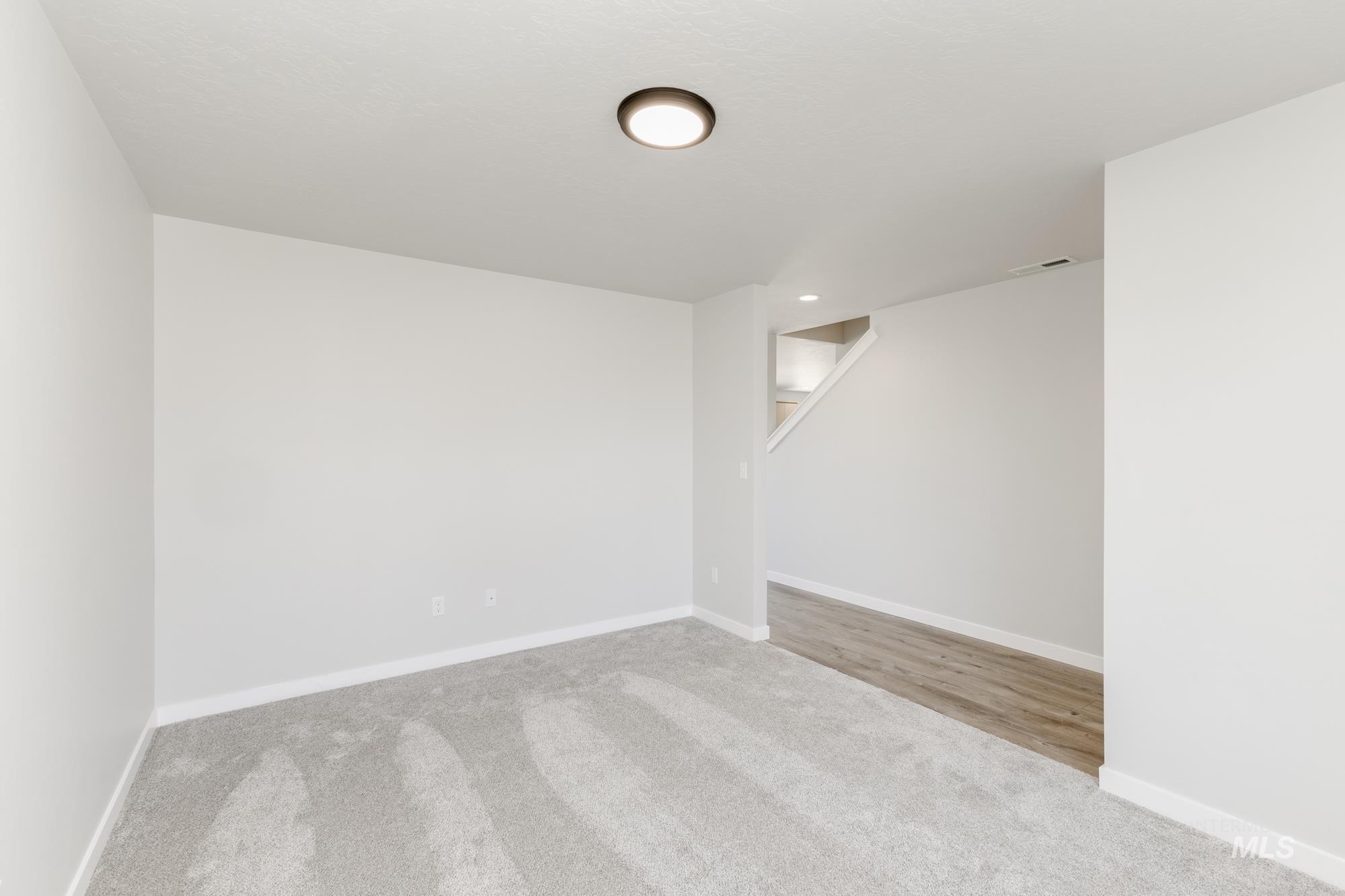 12853 Decatur Street Nampa, ID 83651 - Photo 13 of 24 Open interior space featuring light-toned carpeting and wood-finish flooring