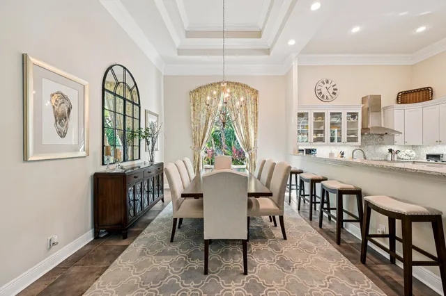 a dining room with furniture a chandelier and wooden floor